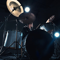 Image showing Drummer rehearsing on drums before rock concert. Man recording music on drum set in studio