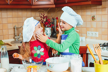 Image showing happy family funny kids are preparing the dough, bake cookies in the kitchen