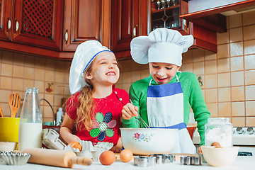 Image showing happy family funny kids are preparing the dough, bake cookies in the kitchen