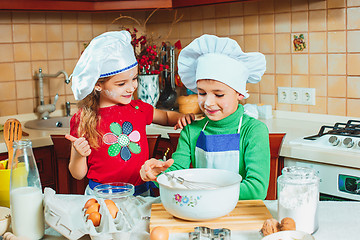 Image showing happy family funny kids are preparing the dough, bake cookies in the kitchen