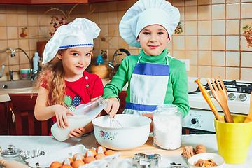 Image showing happy family funny kids are preparing the dough, bake cookies in the kitchen