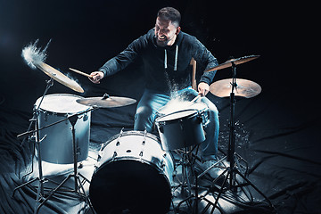 Image showing Drummer rehearsing on drums before rock concert. Man recording music on drum set in studio