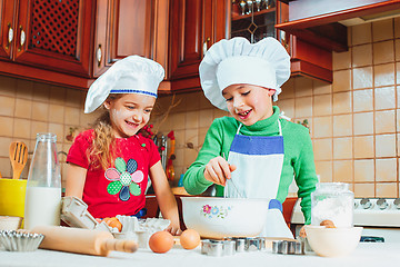 Image showing happy family funny kids are preparing the dough, bake cookies in the kitchen