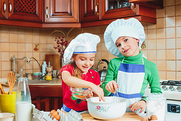 Image showing happy family funny kids are preparing the dough, bake cookies in the kitchen