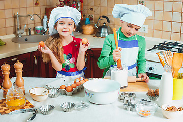 Image showing happy family funny kids are preparing the dough, bake cookies in the kitchen