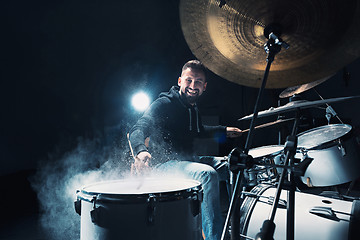 Image showing Drummer rehearsing on drums before rock concert. Man recording music on drum set in studio