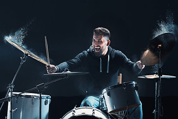 Image showing Drummer rehearsing on drums before rock concert. Man recording music on drum set in studio