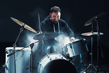 Image showing Drummer rehearsing on drums before rock concert. Man recording music on drum set in studio