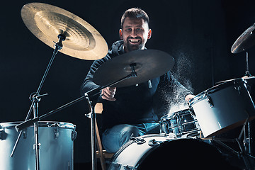 Image showing Drummer rehearsing on drums before rock concert. Man recording music on drum set in studio