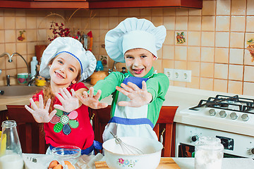 Image showing happy family funny kids are preparing the dough, bake cookies in the kitchen