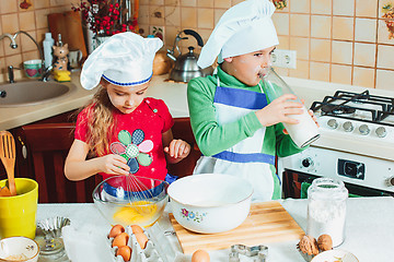 Image showing happy family funny kids are preparing the dough, bake cookies in the kitchen