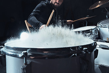 Image showing Drummer rehearsing on drums before rock concert. Man recording music on drum set in studio