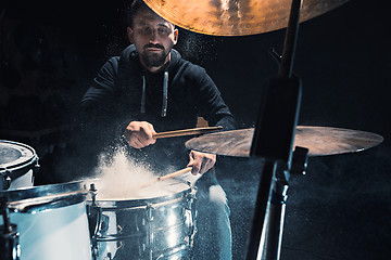 Image showing Drummer rehearsing on drums before rock concert. Man recording music on drum set in studio