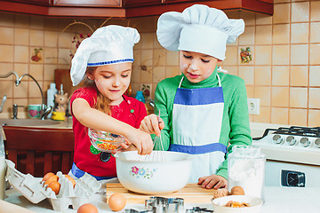 Image showing happy family funny kids are preparing the dough, bake cookies in the kitchen