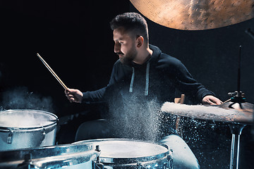 Image showing Drummer rehearsing on drums before rock concert. Man recording music on drum set in studio