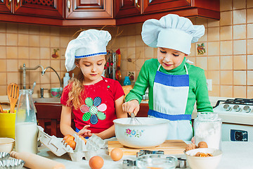 Image showing happy family funny kids are preparing the dough, bake cookies in the kitchen