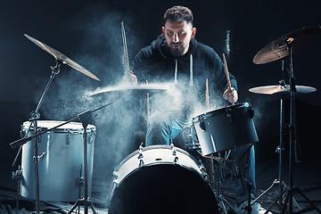 Image showing Drummer rehearsing on drums before rock concert. Man recording music on drum set in studio