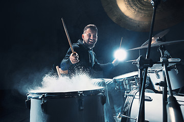 Image showing Drummer rehearsing on drums before rock concert. Man recording music on drum set in studio