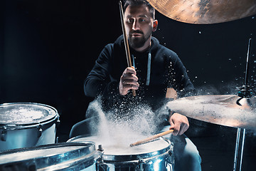 Image showing Drummer rehearsing on drums before rock concert. Man recording music on drum set in studio