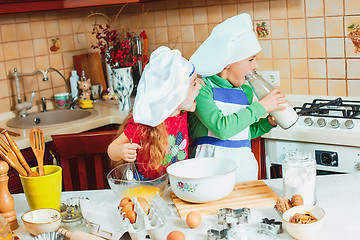 Image showing happy family funny kids are preparing the dough, bake cookies in the kitchen