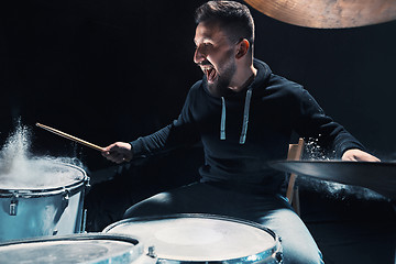 Image showing Drummer rehearsing on drums before rock concert. Man recording music on drum set in studio