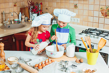 Image showing happy family funny kids are preparing the dough, bake cookies in the kitchen