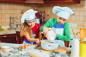 Image showing happy family funny kids are preparing the dough, bake cookies in the kitchen