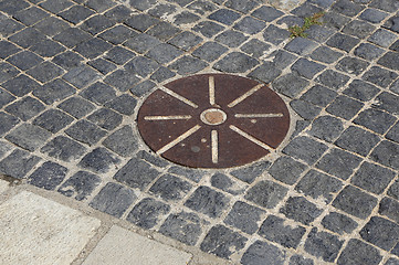 Image showing Cobblestones pavement with metal round detail