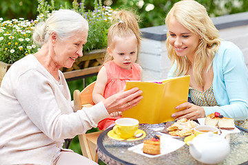 Image showing happy family reading book at cafe