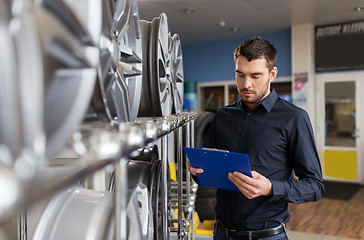 Image showing auto business owner and wheel rims at car service