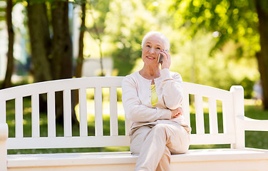 Image showing happy senior woman calling on smartphone in summer