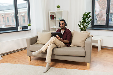 Image showing man in phones with tablet pc listening to music