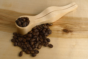 Image showing coffee measuring spoon and coffee beans on a wooden board