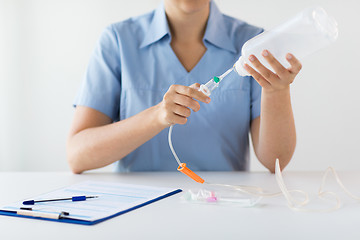 Image showing close up of nurse preparing drop counter