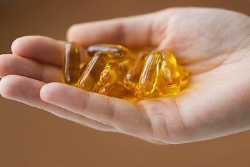 Image showing hand holding cod liver oil capsules