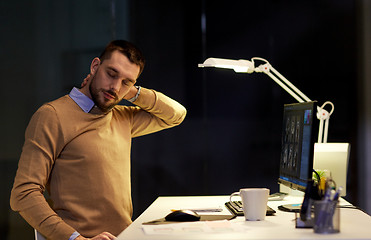 Image showing tired man having neck ache working at night office