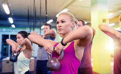 Image showing group of people with kettlebells exercising in gym