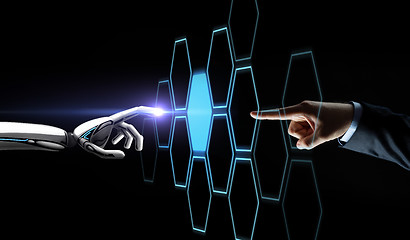 Image showing robot and human hand touching network hologram
