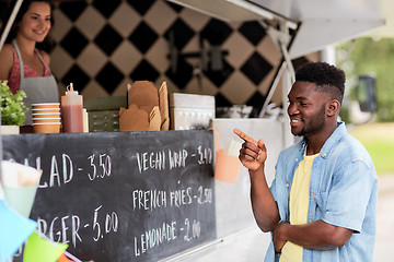 Image showing male customer looking at billboard at food truck