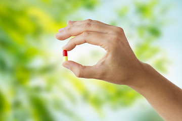 Image showing close up of hand holding capsule of medicine
