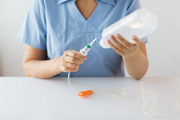 Image showing close up of nurse preparing drop counter