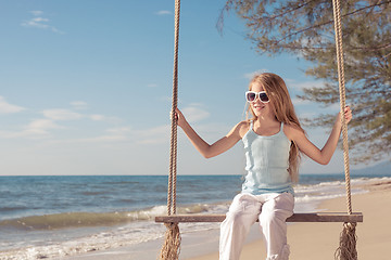 Image showing One happy little girl playing on the beach at the day time.