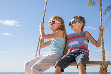 Image showing Two happy little children playing on the beach at the day time.