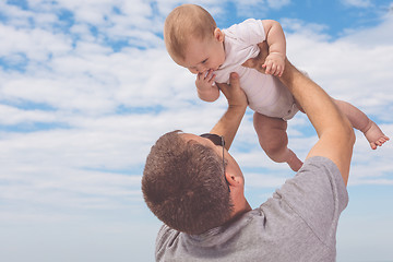 Image showing Father and son playing on the beach at the day time.