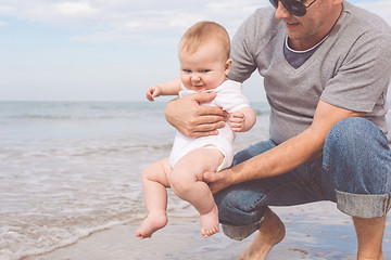 Image showing Father and son playing on the beach at the day time.