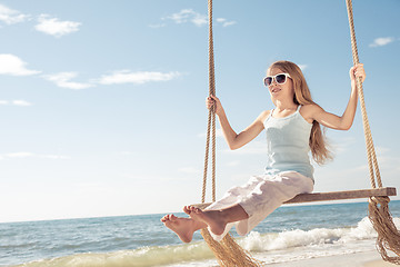 Image showing One happy little girl playing on the beach at the day time.