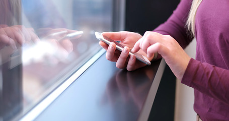 Image showing Close up of business woman using cell phone in office interior