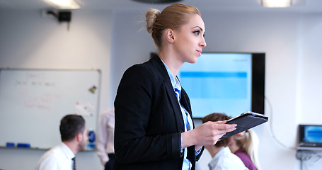 Image showing Businesswoman using tablet with coworkers in backgorund having m