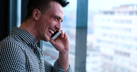 Image showing Business Man Talking On Cell Phone, Looking Out Office Window