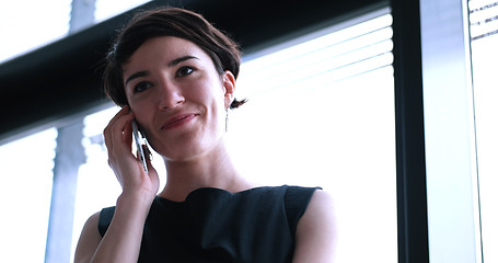 Image showing Business Girl Standing In A Modern Building Near The Window With